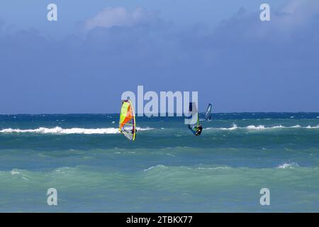 Deux planches à voile méconnaissables à l'horizon à Kanaha Beach sur Maui. Banque D'Images