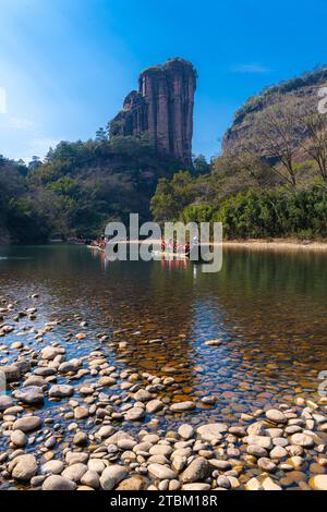 Un rivage rocheux sur la rivière Nine Bend ou Jiuxi à Wuyishan ou la région pittoresque du mont Wuyi à Wuyi en Chine dans la province du Fujian. Ciel bleu profond, image verticale Banque D'Images