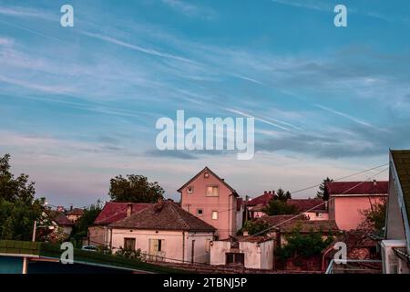 Sentiers chimiques dans le ciel au-dessus des maisons de la banlieue Banque D'Images