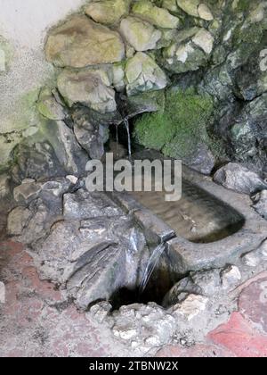 St. Gilgen, Autriche. 30 août 2023. L'eau miraculeuse, que les devins décrivent comme ayant une forte rotation dans le sens des aiguilles d'une montre, monte d'une source qui est dit de retourner à Saint Wolfgang et autour duquel une chapelle a été construite sur le chemin de pèlerinage sur le Falkenstein sur le lac Wolfgangsee dans le Salzkammergut en Autriche. Le Salzkammergut est la capitale de la culture 2024. Crédit : Beate Schleep/dpa/Alamy Live News Banque D'Images