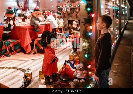 Enfant regardant dans la vitrine décorée pour Noël Banque D'Images