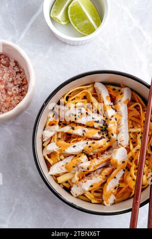 Nouilles asiatiques traditionnelles avec légumes et poulet dans un bol Banque D'Images