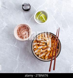 Nouilles asiatiques traditionnelles avec légumes et poulet dans un bol Banque D'Images