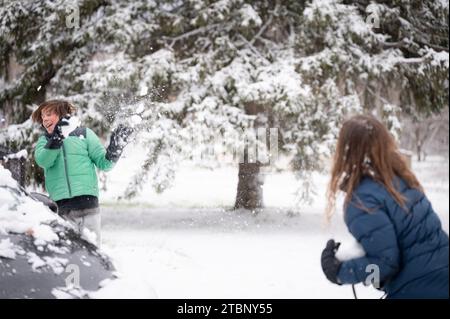 Frères ayant un combat de boules de neige en hiver Banque D'Images