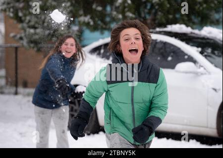 Joyeux frères adolescents ayant un combat de boules de neige en hiver Banque D'Images