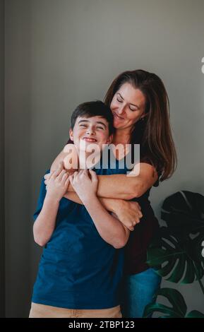 Mère et fils heureux s'amusant embrassant de manière ludique à la maison. Banque D'Images