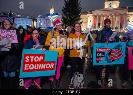 Londres, Royaume-Uni. 07 décembre 2023. Les manifestants chantent des chants de Noël tout en brandissant des pancartes pendant la manifestation sur le Trafalgar Square à Londres. Les activistes de extinction Rebellion ont organisé une manifestation lors de la cérémonie officielle des lumières de Noël pour protester contre les plans d'Equinor, basé en Norvège, de développer le champ pétrolifère de Rosebank au Royaume-Uni. (Photo Krisztian Elek/SOPA Images/Sipa USA) crédit : SIPA USA/Alamy Live News Banque D'Images