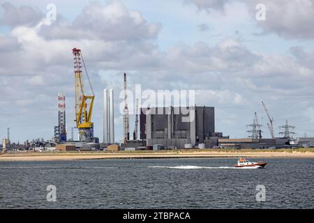 Hartlepool Advanced Gas Cooled Reactor Nuclear Power Station (réacteur à refroidissement au gaz avancé de Hartlepool) éclipsée par la grue du navire de soutien offshore, Voltaire, Teesside, Banque D'Images