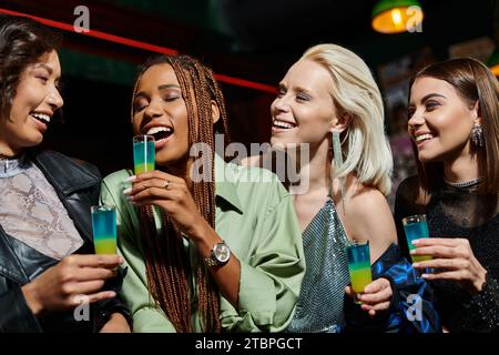 femme afro-américaine excitée avec les yeux fermés et lunettes de tir près de copines multiethniques Banque D'Images