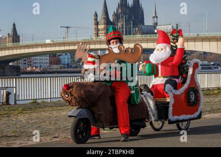 Père Noël sur un scooter Vespa décoré comme un renne et un traîneau, les membres du club de scooter Vespa RheinSchalter Koeln habillés comme Santas se rassemblent sur D. Banque D'Images