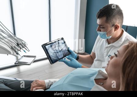 Le dentiste examine attentivement l'état de la cavité buccale du patient sur les images TDM et IRM et développe un plan de traitement individuel. Un moderne Banque D'Images