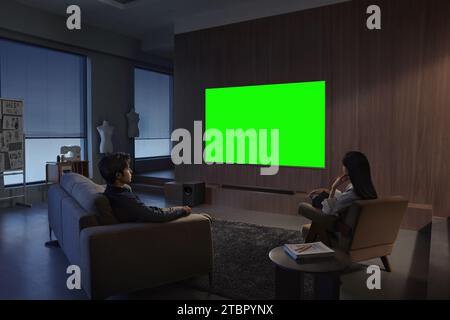 Les gens regardent et apprécient à côté de la télévision, moniteur avec écran vert Banque D'Images