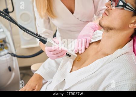 L'homme subit l'épilation laser de la poitrine dans le salon de beauté Banque D'Images