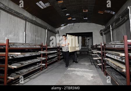 (231208) -- JINGXIAN, 8 décembre 2023 (Xinhua) -- Wu Fan prépare le séchage du papier humide dans un atelier de papier Xuan dans le comté de Jingxian, dans la province d'Anhui, dans l'est de la Chine, le 6 décembre 2023. Le papier Xuan, un type de papier fait à la main, a été produit à l'origine dans la Chine ancienne et utilisé pour la calligraphie chinoise et les peintures. La procédure de fabrication du papier Xuan a été classée patrimoine culturel mondial immatériel par l'UNESCO en 2009. Jingxian, un comté sous la ville de Xuancheng dans la province d'Anhui, est l'endroit même où le papier Xuan a été inventé. Guan Jiaming, responsable du processus de moulage du papier dans un atelier de Xuan Banque D'Images