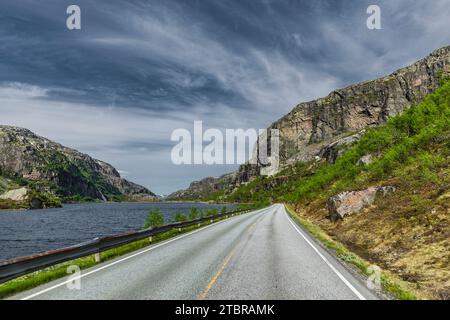 Route asphaltée par un lac en Norvège Banque D'Images