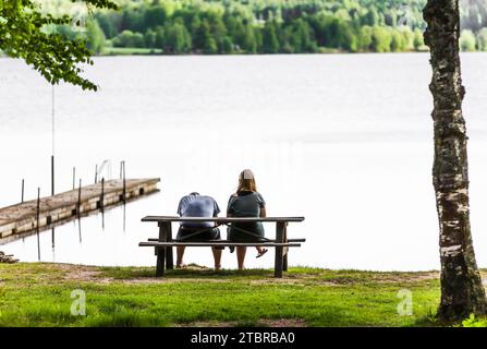 Couple sur un banc au bord du lac Banque D'Images