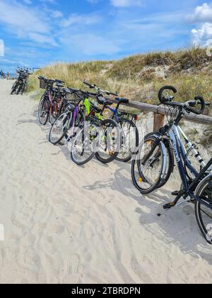 Allemagne, Mecklembourg-Poméranie occidentale, péninsule Fischland-Darß-Zingst, Prerow, vue sur les vélos à la plage traversant sur une belle journée d'été avec ciel bleu et nuages Banque D'Images