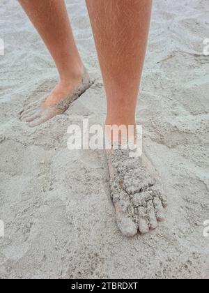 Allemagne, Mecklembourg-Poméranie occidentale, péninsule Fischland-Darß-Zingst, pieds d'homme couverts de sable sur la plage de sable Prerow Banque D'Images