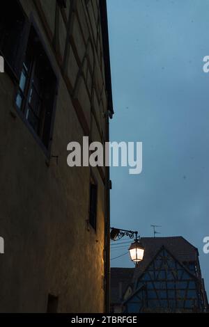 Vue vers le ciel à côté des façades de maisons rustiques à l'ancienne Riquewihr, France, Alsace Banque D'Images