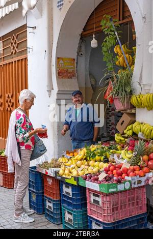 Touriste occidental achetant des fruits du vendeur marocain à la boutique dans la médina de la ville Tanger / Tanger, Maroc Banque D'Images