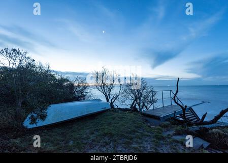 Aube sur la plage de Hovmarken sur l'île danoise de Mön dans la mer Baltique, bateau à rames, escalier, Mön, Danemark Banque D'Images