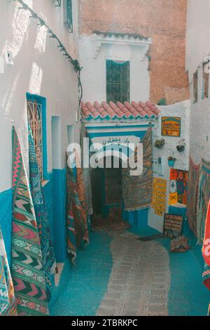 Chefchaouen, Maroc. 14 octobre 2022 - magasin de tapis au bout d'une petite rue, avec quelques tapis sur le mur Banque D'Images