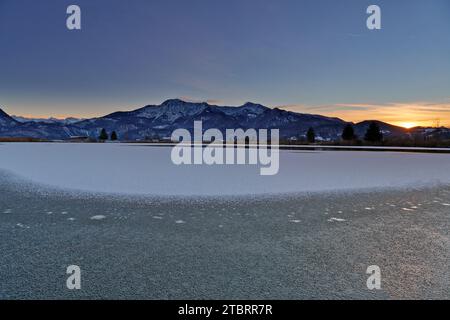 Coucher de soleil à l'Eichsee gelé vers Herzogstand et Heimgarten Banque D'Images