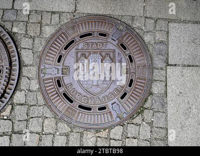 Allemagne, Bavière, haute-Bavière, district de Altötting, Burghausen, vieille ville, couverture de trou d'homme avec blasons de ville, pavés Banque D'Images