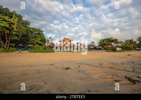 Lever de soleil sur plage de sable, paysage tourné avec vue sur la mer et la plage, vagues légères et belle ambiance matinale, Sanur, Bali, Indonésie Banque D'Images