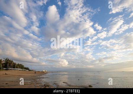 Lever de soleil sur plage de sable, paysage tourné avec vue sur la mer et la plage, vagues légères et belle ambiance matinale, Sanur, Bali, Indonésie Banque D'Images