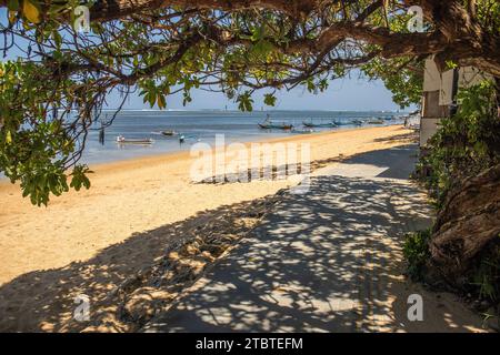 Lever de soleil sur plage de sable, paysage tourné avec vue sur la mer et la plage, vagues légères et belle ambiance matinale, Sanur, Bali, Indonésie Banque D'Images