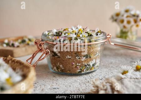 Faire du sirop à base de plantes maison à partir de fleurs fraîches de Marguerite commune et de sucre de canne Banque D'Images