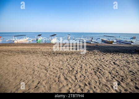 Jukung sur la plage au bord de la mer, bateau de pêche traditionnel dans la lumière du matin à Lovina, Bali Banque D'Images