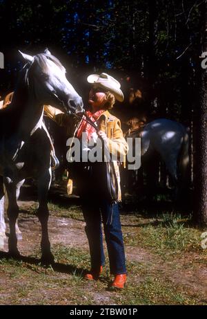 JASPER, AB - JUILLET 1954 : vue générale en tant que cavalier de femme repose et caresse son cheval tout en s'aventurant à travers le sentier Jasper à cheval vers juillet 1954 à Jasper, Alberta, Canada. (Photo de Hy Peskin) Banque D'Images