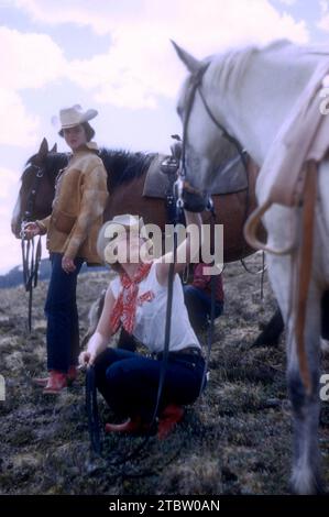 JASPER, AB - JUILLET 1954 : vue générale en tant que groupe de cavalières femmes se reposent et fument tout en s'aventurant à travers le sentier Jasper à cheval vers juillet 1954 à Jasper, Alberta, Canada. (Photo de Hy Peskin) Banque D'Images