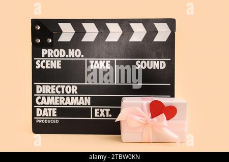 clapper de film et boîte-cadeau sur fond jaune. Fête de la Saint-Valentin Banque D'Images