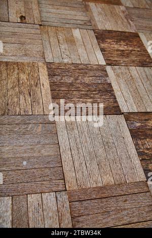 Vue de la texture rustique de plancher en bois à chevrons dans les tons chauds gros plan Banque D'Images