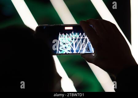 New York, New York, États-Unis. 7 décembre 2023. Quelqu'un enregistre des images téléphoniques de la plus grande menorah du monde allumée sur la 59e rue et la 5e Avenue pour la première nuit de Hanoukka. (Image de crédit : © Edna Leshowitz/ZUMA Press Wire) USAGE ÉDITORIAL SEULEMENT! Non destiné à UN USAGE commercial ! Banque D'Images