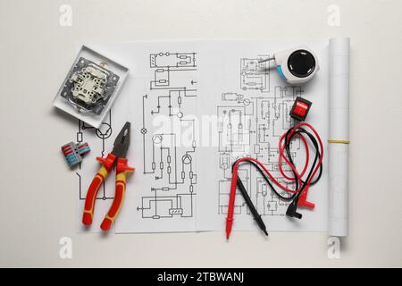 Schémas de câblage, différents équipements d'électricien et pinces sur fond blanc, vue de dessus Banque D'Images