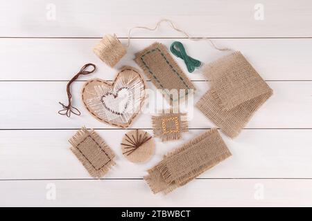 Composition de pose à plat avec des morceaux de toile de jute sur la table en bois blanc Banque D'Images