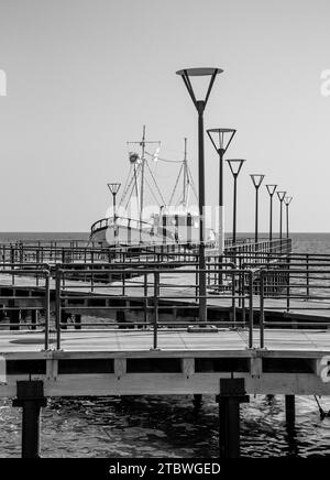 Une photo en noir et blanc d'un bateau de pêche reposant à côté d'une jetée, à Limassol Banque D'Images