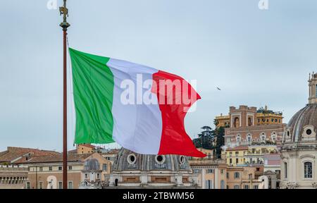 Une photo d'un grand drapeau italien agitant à côté de quelques points de repère Banque D'Images