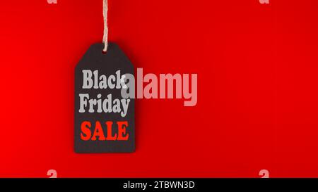 Black Friday sale tag sur fond rouge dans un format panoramique à utiliser comme en-tête ou bannière Web avec espace de copie pour le texte. Soldes du Vendredi fou, shopping Banque D'Images