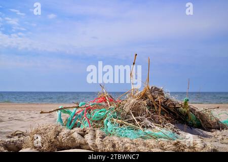 Grande pile de corde rejetée et ficelle en plastique emmêlée lavée sur une plage de sable dans un concept de pollution environnementale Banque D'Images