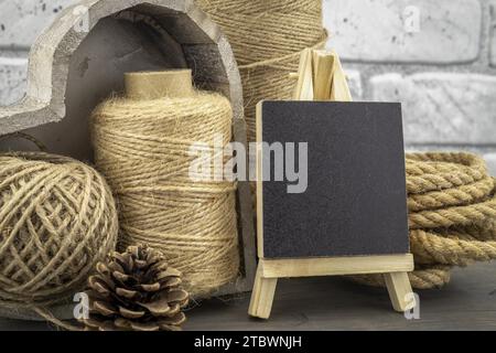 Assortiment de boules de ficelle de chanvre et de ficelle avec des pelotes de corde et ardoise tableau noir dans une vie rustique de gros plan Banque D'Images