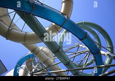 Les pipes colorées du parc aquatique ont vu un angle bas contre un ciel bleu dans un concept architectural Banque D'Images