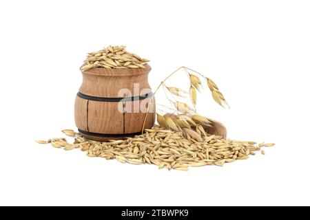 Tas de grains d'avoine biologique avec des coques ou des enveloppes dans un petit tonneau en bois isolé sur fond blanc. Grains d'avoine entiers avec enveloppe. Agriculture, alimentation Banque D'Images