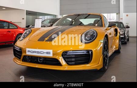 Photo d'une Porsche 911 Turbo S orange à l'intérieur d'une concession Banque D'Images