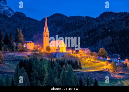 L'église Chiesa di San Lorenzo Martire à Selva di Cadore au pied du col de Giau, Passo di Giau, illuminée la nuit en automne . Banque D'Images