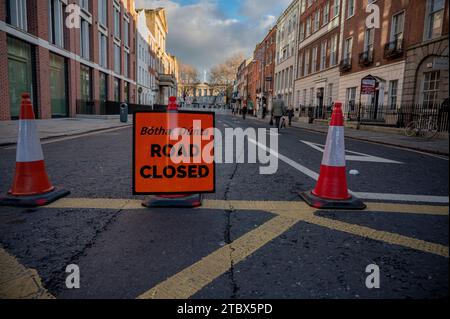 Des barrières entourent le Parlement irlandais après les émeutes de Dublin pour empêcher les manifestants d'entrer. Le 23 novembre 2023, Dublin a connu l'une des émeutes les plus graves de son histoire depuis l'indépendance. À la suite de la tentative de poignarder trois enfants devant une école du centre-ville, les dirigeants irlandais d'extrême droite ont appelé leurs partisans sur la rue O'Connell, l'artère centrale de Dublin, à protester violemment contre les immigrants et les politiques d'accueil du pays. Les violentes émeutes ont forcé certains magasins pillés à fermer pendant des jours. Banque D'Images